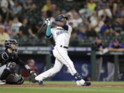 Seattle Mariners' Shed Long Jr. hits a solo home run on a pitch from Colorado Rockies' Tyler Kinley during the eighth inning of a baseball game, Tuesday, June 22, 2021, in Seattle.