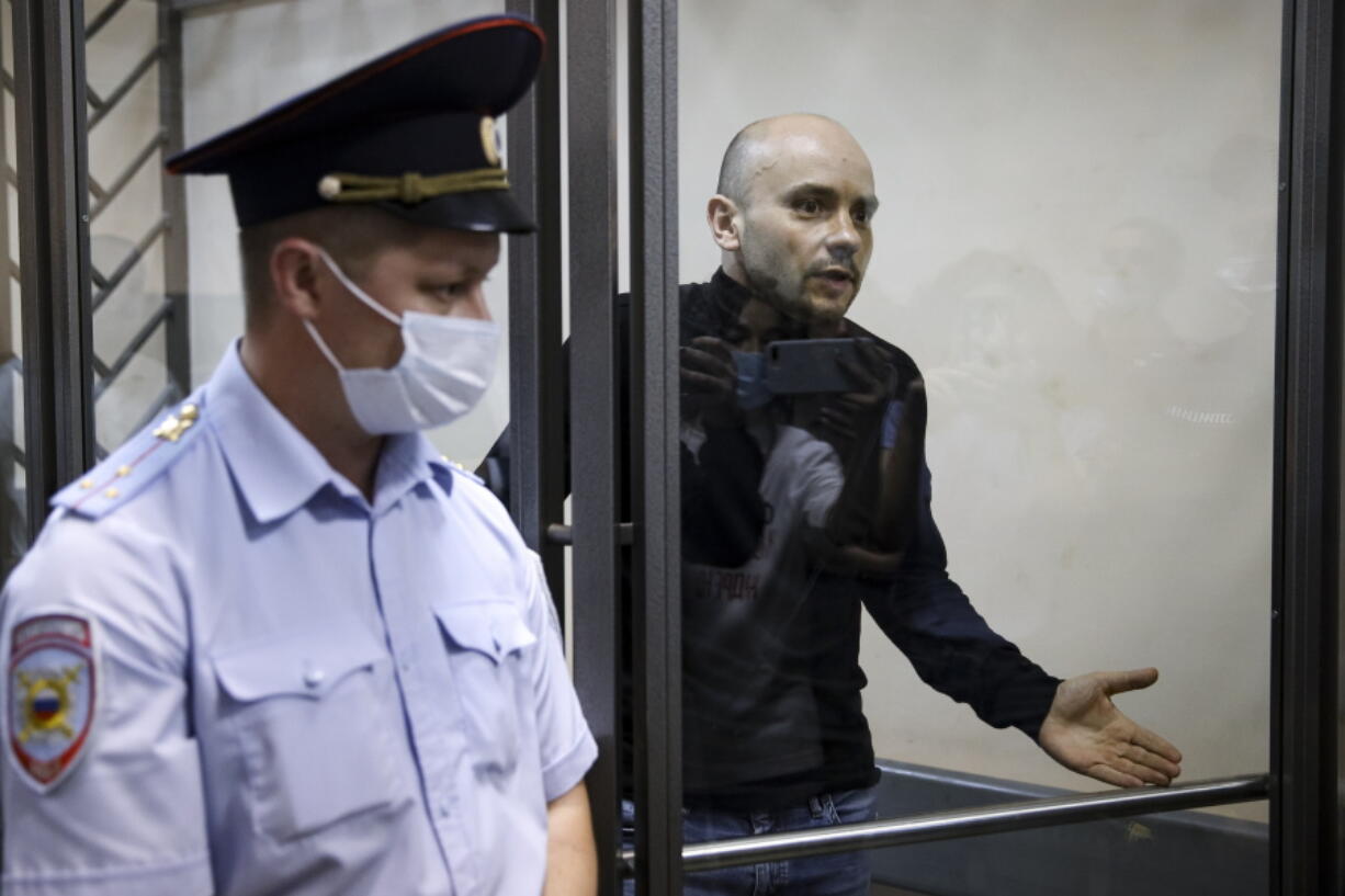 Andrei Pivovarov, the head of Open Russia movement gestures standing behind the glass during a court session in Krasnodar, Russia, Wednesday, June 2, 2021. In the southern city of Krasnodar, a court was scheduled to consider whether to keep Andrei Pivovarov, the head of the Open Russia movement, in custody pending an investigation. Pivovarov was pulled off a Warsaw-bound plane at St. Petersburg's airport just before takeoff late Monday and taken to Krasnodar, where authorities accused him of supporting a local election candidate last year on behalf of an "undesirable" organization.