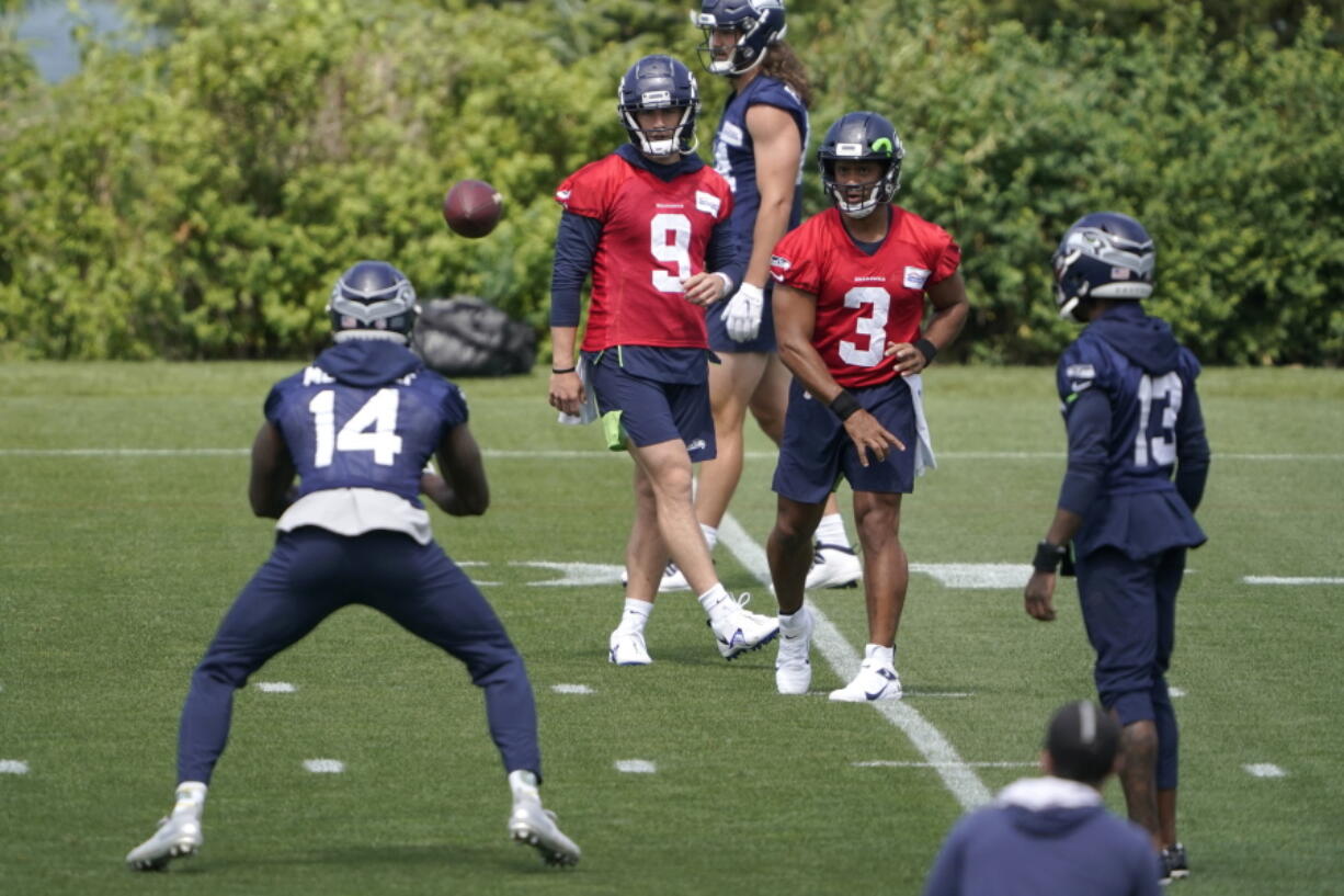 Seattle Seahawks quarterback Russell Wilson (3) passes to wide receiver DK Metcalf (14) during NFL football practice Tuesday, June 8, 2021, in Renton, as quarterback Danny Etling (9) and wide receiver Darvin Kidsy (23) look on. (AP Photo/Ted S.