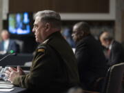 From left, Chairman of the Joint Chiefs of Staff Gen. Mark Milley, accompanied by Secretary of Defense Lloyd Austin, and Defense Under Secretary Mike McCord, speaks at a Senate Armed Services budget hearing on Capitol Hill in Washington, Thursday, June 10, 2021.