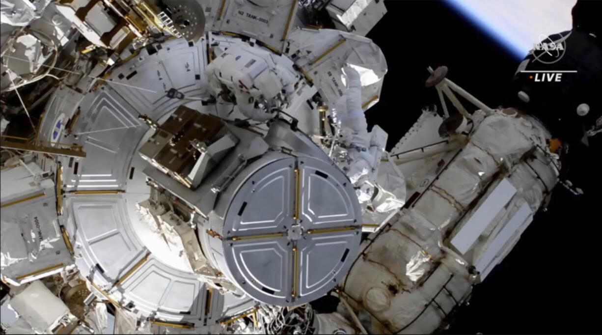 This photo provided by NASA shows astronauts NASA's Shane Kimbrough and France's Thomas Pesquet during a space walk outside the International Space Station on Friday, June 25, 2021.  The astronauts are working to install another new solar panel outside the station.