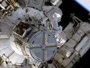 This photo provided by NASA shows astronauts NASA's Shane Kimbrough and France's Thomas Pesquet during a space walk outside the International Space Station on Friday, June 25, 2021.  The astronauts are working to install another new solar panel outside the station.