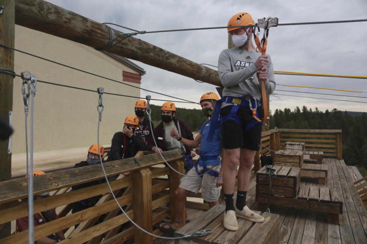 Glorieta Adventure Camp counselor Kole Linville, of Kentucky, trains on a zip line on Friday, May 21, 2021, in Glorieta, N.M., before campers arrive. The 3,000-bed camp outside Santa Fe opened up at a third of its normal capacity under pandemic restrictions after being closed last year. Campers and staff will be kept in pods of 10 or less, wear masks outside their sleeping quarters, and eat outdoors to prevent outbreaks.