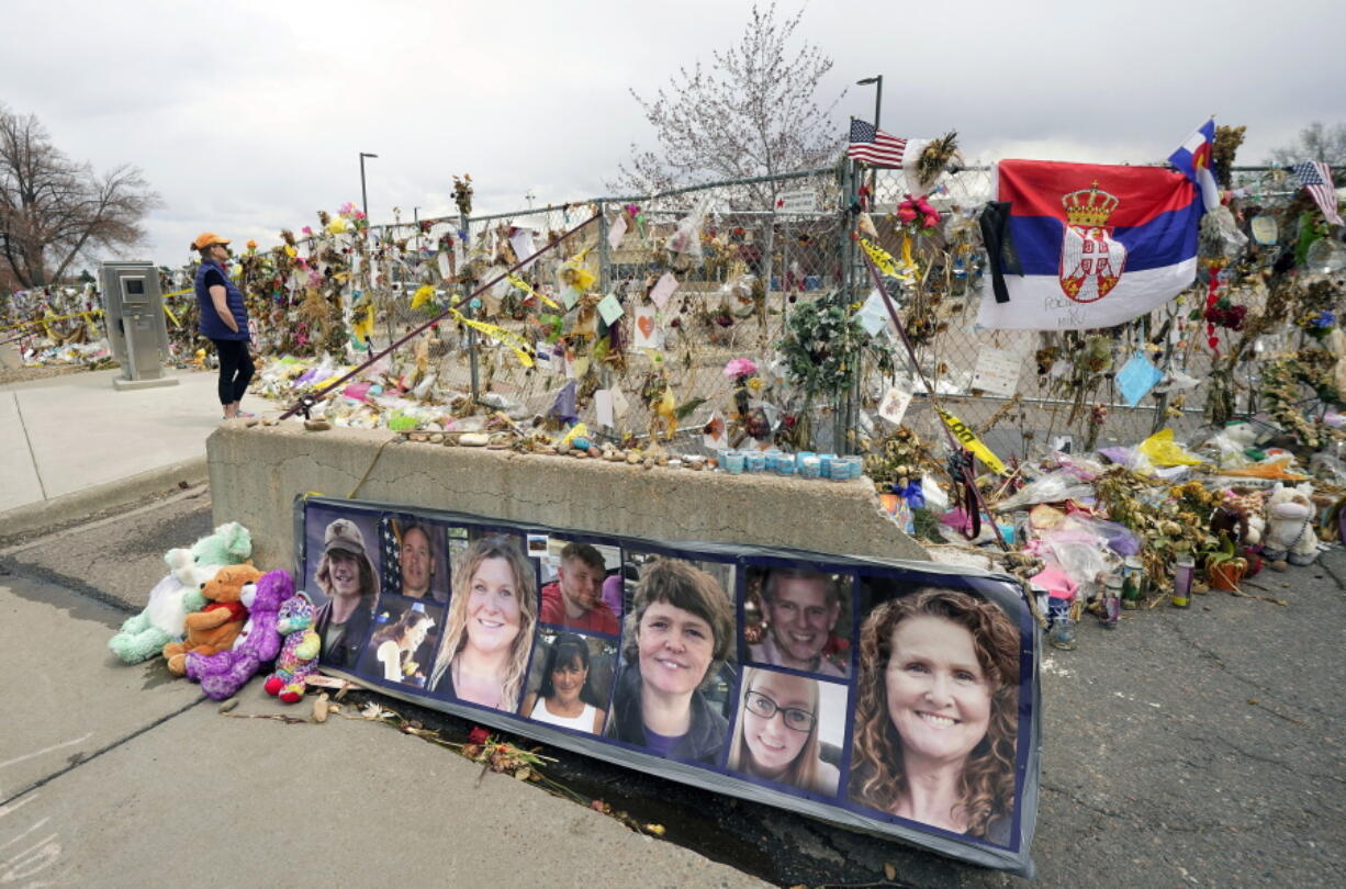 FILE - In this Friday, April 23, 2021, file photo, photographs of the 10 victims of a mass shooting in a King Soopers grocery store are posted on a cement barrier outside the supermarket in Boulder, Colo. Several families and survivors of those killed in the mass shooting at a Colorado supermarket are demanding that a special master be appointed to help distribute public donations for victims to a centralized account, saying the nonprofits currently handling the funds are not giving all of the money directly to victims.