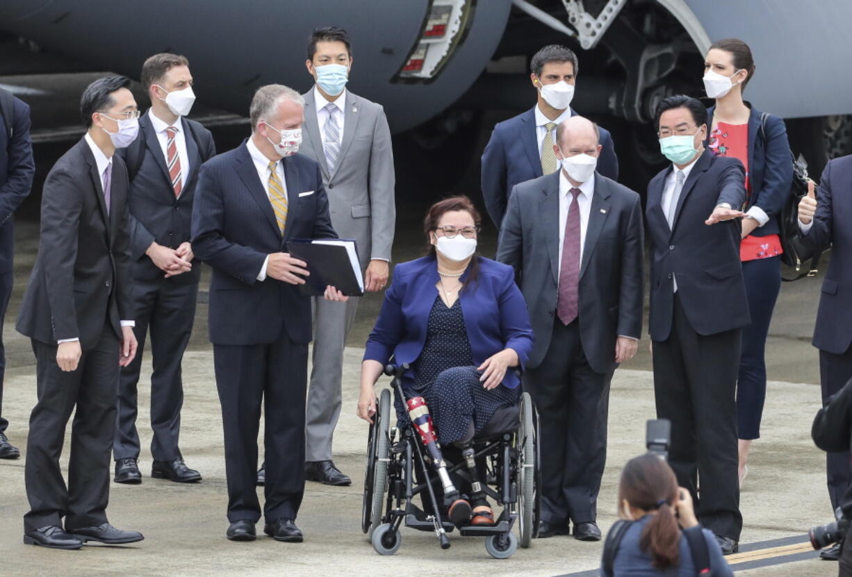 Taiwan's Foreign Minister Joseph Wu, second right, gestures as he welcomes U.S. senators to his right Democratic Sen. Christopher Coons of Delaware, a member of the Foreign Relations Committee, Democratic Sen. Tammy Duckworth of Illinois and Republican Sen. Dan Sullivan of Alaska, members of the Armed Services Committee on their arrival at the Songshan Airport in Taipei, Taiwan on Sunday, June 6, 2021. The three U.S. senators arrived in Taiwan to meet with senior government officials and discuss U.S.-Taiwan relations and other issues in a trip that is likely to anger China, which claims Taiwan as its territory and objects to Taiwan being called a country.