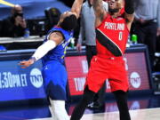 Portland Trail Blazers guard Damian Lillard (0) shoots a 3-point basket against Denver Nuggets guard Shaquille Harrison (3) to send Game 5 of a first-round NBA basketball playoff series into a second overtime, Tuesday, June 1, 2021, in Denver.