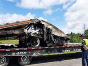 Some of the wreckage from a fatal multiple-vehicle crash a day earlier is loaded to be carried away, Sunday, June 20, 2021, in Butler County, Ala.