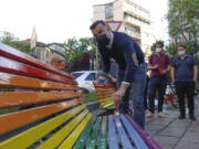 FILE - In this Friday, May 7, 2021 filer, Italian lawmaker Alessandro Zan paints a bench in the colors of the rainbow, in Milan, Italy. The Vatican has formally opposed proposed Italian legislation that seeks expand anti-discrimination protections to people who are gay and transgender, along with women and people with disabilities, the leading Italian daily Corriere della Sera reported on Tuesday. Activists immediately denounced Vatican meddling in the Italian legislative process as "unprecedented. Italian politicians and activist groups reacted strongly to what they see as an attempt to derail the so-called Zan Law, named for a Democratic Party lawmaker and gay rights activist Alessandro Zan.