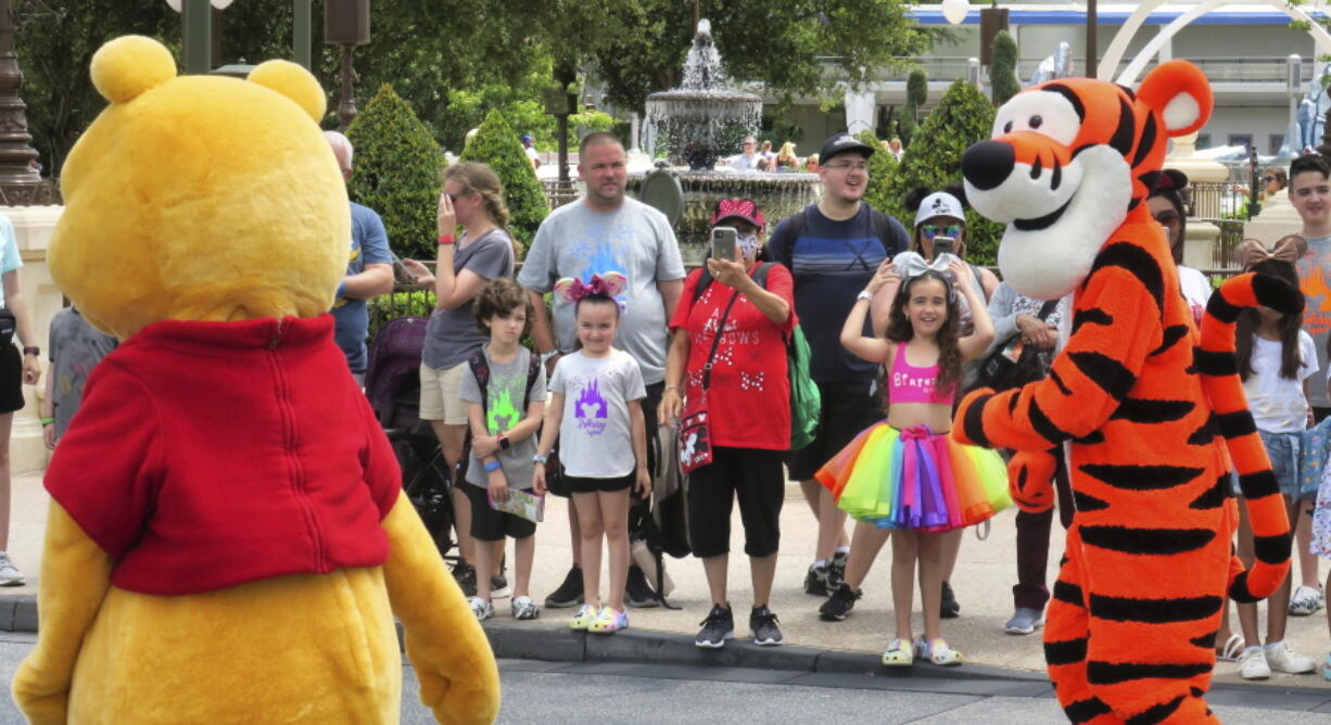 Young guests enjoy seeing Winnie The Pooh, and Tigger too, at the Magic Kingdom at Walt Disney World, in Lake Buena Vista, Fla., Monday, May 17, 2021, after Disney Co. eased face mask requirements over the weekend. Guests are allowed to go maskless in outdoor areas of the parks. Indoor attractions, shops and Disney transportation at the resort all still require masks.