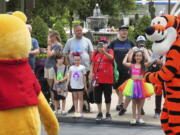 Young guests enjoy seeing Winnie The Pooh, and Tigger too, at the Magic Kingdom at Walt Disney World, in Lake Buena Vista, Fla., Monday, May 17, 2021, after Disney Co. eased face mask requirements over the weekend. Guests are allowed to go maskless in outdoor areas of the parks. Indoor attractions, shops and Disney transportation at the resort all still require masks.