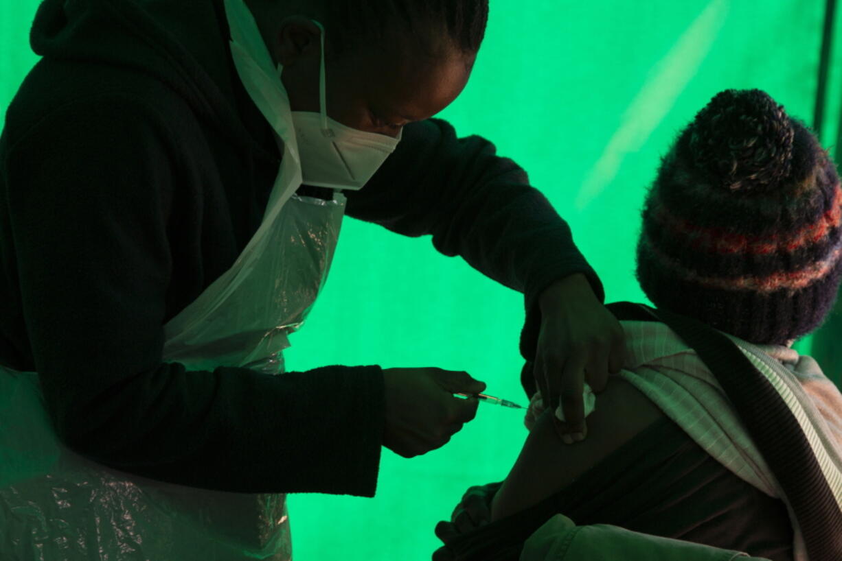 FILE - In this June 3, 2021, file photo, an elderly patient receives a Pfizer COVID-19 vaccine at a clinic at Orange Farm, near Johannesburg. In the global race to vaccinate people against COVID-19, Africa is tragically at the back of the pack.