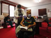 In this photo taken May 5, 2021, Melanie Paige closes her eyes as she gets her first COVID-19 vaccination at her church, St. Matthew Christian Methodist Episcopal, in Milwaukee. It's one of the churches that was part of an effort with Pastors United, Milwaukee Inner City Congregations Allied for Hope, Souls to the Polls and the local health clinic Health Connections to get people vaccinated directly in churches.