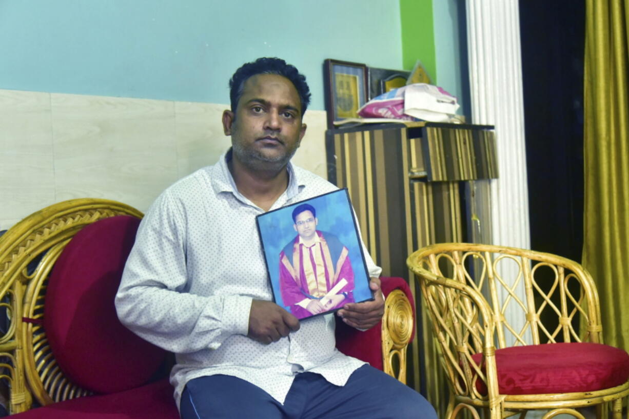 A relative holds a photograph of Dr. Jibraeil, assistant professor of history at Aligarh Muslim Uliversity, who died of COVID-19, in Aligarh, India, Saturday, June 12, 2021. Within just one month, the official Facebook page of Aligarh Muslim University, one of the topmost in India, published about two dozen obituaries of its teachers, all lost to the pandemic.