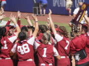 Oklahoma players celebrate with the trophy after defeating Florida State in the final game of the NCAA Women's College World Series softball championship series Thursday, June 10, 2021, in Oklahoma City.