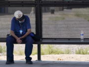 A person waits for a bus in the shade as the heat wave in the Western states continues Thursday, June 17, 2021, in Phoenix. (AP Photo/Ross D.