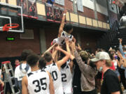 Union High School players and fans hoist Izaiah Vongnath after Vongnath cut down the net following Union's 61-60 victory over Skyview in Friday's 4A/3A GSHL district championship in boys basketball.