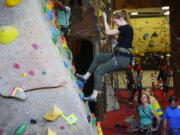 A climber tests a beginners wall, learning top-roping techniques during a Climbing 101 class at Stone Gardens in Seattle.