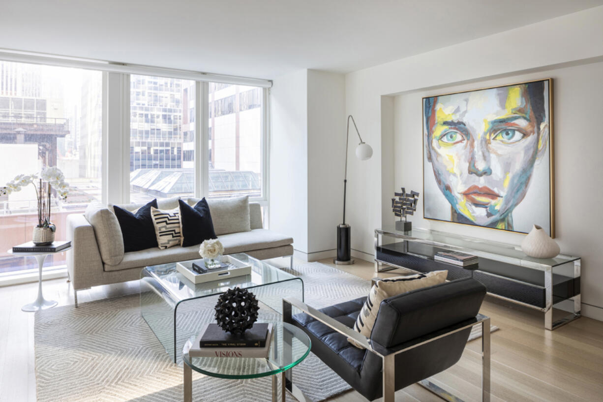 A bold piece of artwork with dominant accents of chartreuse serves as a focal point in this living room.