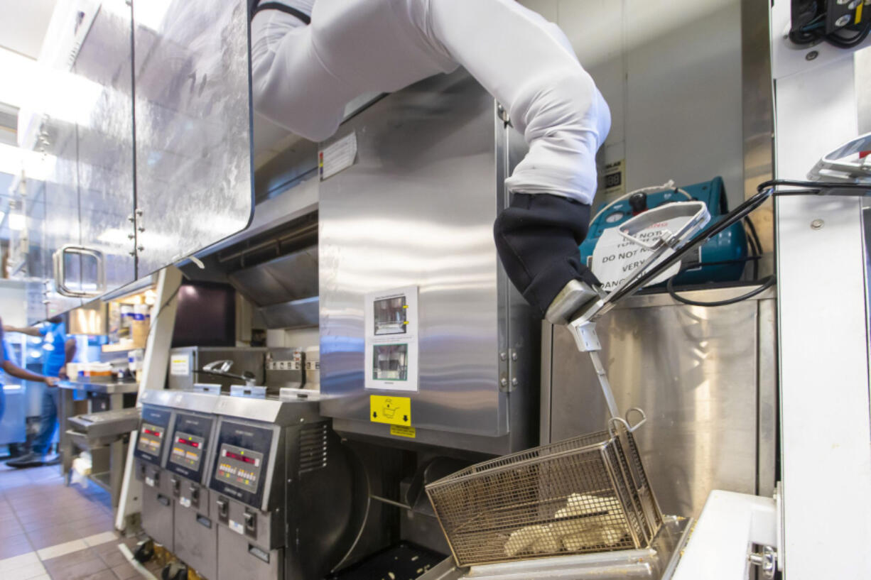Miso Robotics' Flippy ROAR grabs a basket of cheese sticks for the fryer at a White Castle in Merrillville, Ind., on July 6, 2021. This location is testing "Flippy ROAR," a robotic fryer by Miso Robotics and an automated voice that takes orders at the drive-thru.