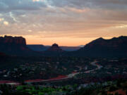 Overcast skies as the sun sets over the Verde Valley region, as people watch the sunset from atop of the summit of the Airport Mesa Loop Trail on Monday, April 20, 2020 in Sedona, Arizona.