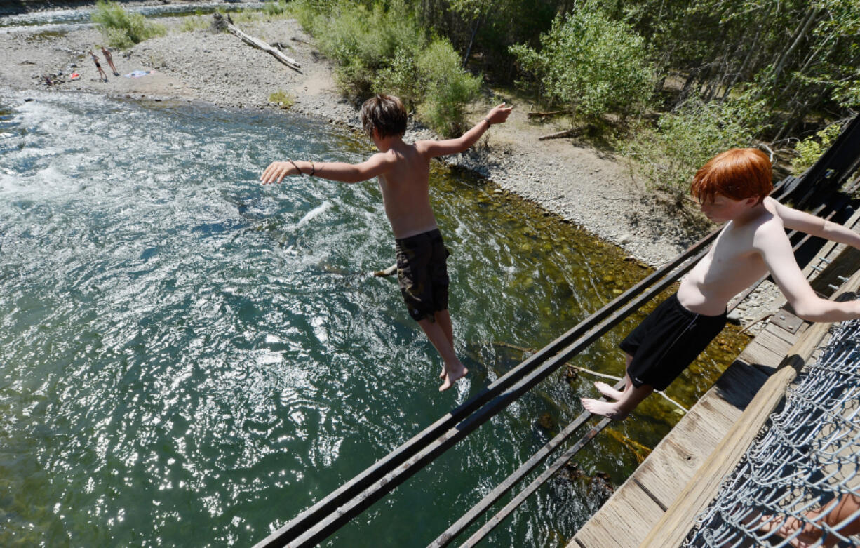 Young swimmers cool off by jumping into the Big Wood River from an old train bridge in Sun Valley, Idaho, on July 9, 2012. A surprise drought has been accompanied by an extreme heat wave in parts of Idaho this summer.