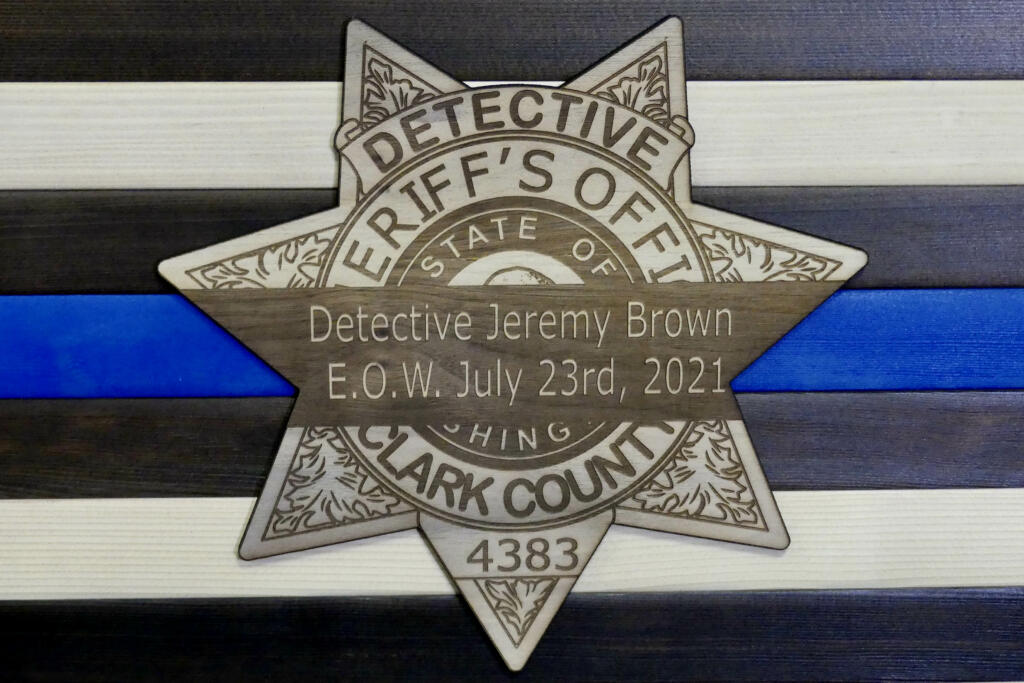 A memorial for Clark County sheriff's Detective Jeremy Brown depicts a mourning band over a badge with his end of watch date.