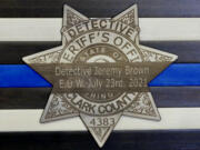 A memorial for Clark County sheriff's Detective Jeremy Brown depicts a mourning band over a badge with his end of watch date.