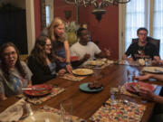 Julie McCormick, the director of the Pittsburgh Fellows program, takes a plate from the table on May 3 at her home in Sewickley, Penn. Every Monday, McCormick hosts a dinner for the fellows.