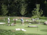 John Hardman, left, and David Buhlmann, both of Hood River, Ore., play a round of golf on the new 18-hole putting course Wednesday at Skamania Lodge in Stevenson.