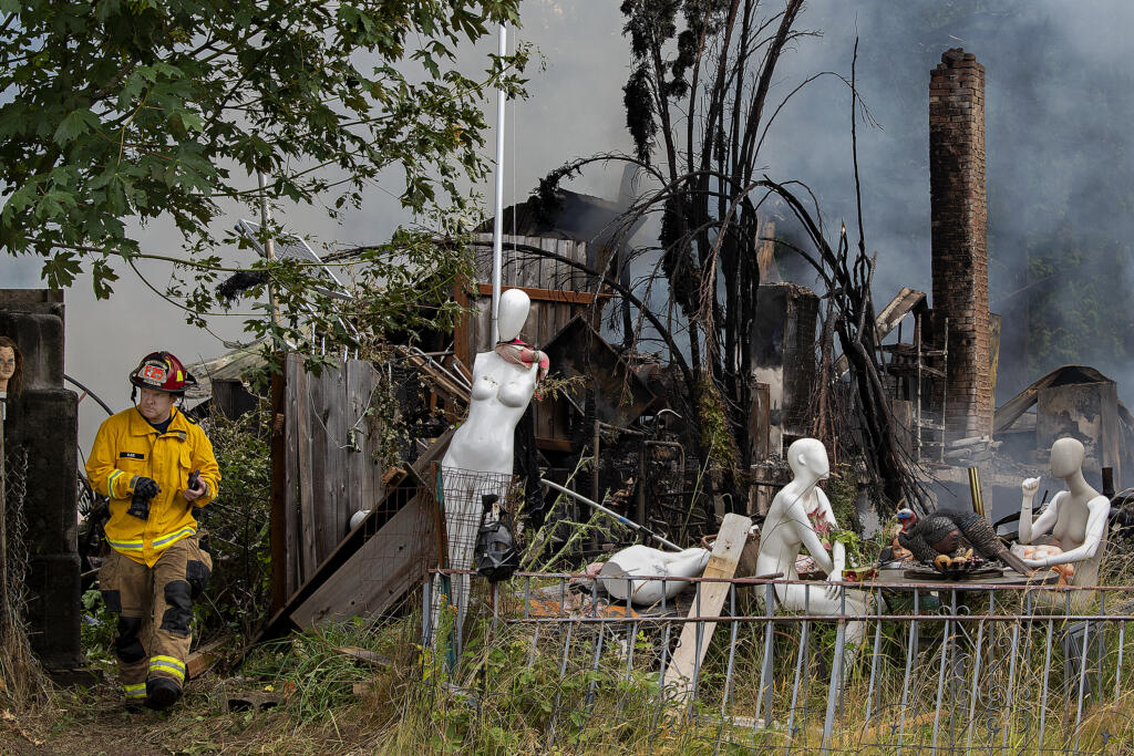 Captain Kenny Bjur of Clark-Cowlitz Fire Rescue lends a hand at the scene on Northeast 92nd Avenue in Battle Ground on Monday morning, July 5, 2021.