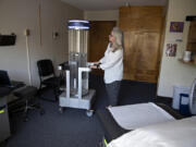 Sue Neal, executive director of Battle Ground HealthCare, looks over a rapid disinfector ultraviolet light sterilizer that helps fight COVID-19. The free clinic provides a range of health care services, which will be expanded at the new location.