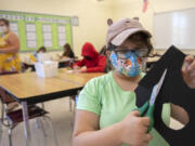 Maddie Ackerman, 13, tackles a project during a summer school art class at Covington Middle School on Tuesday morning. Evergreen Public Schools is expanding summer school offerings to middle school students for the first time, in subjects ranging from algebra readiness to science, plus a host of Social Emotional Learning options.