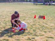 WOODLAND: Brian Peterson, third-grade teacher, helps a student prepare a rocket for launch.