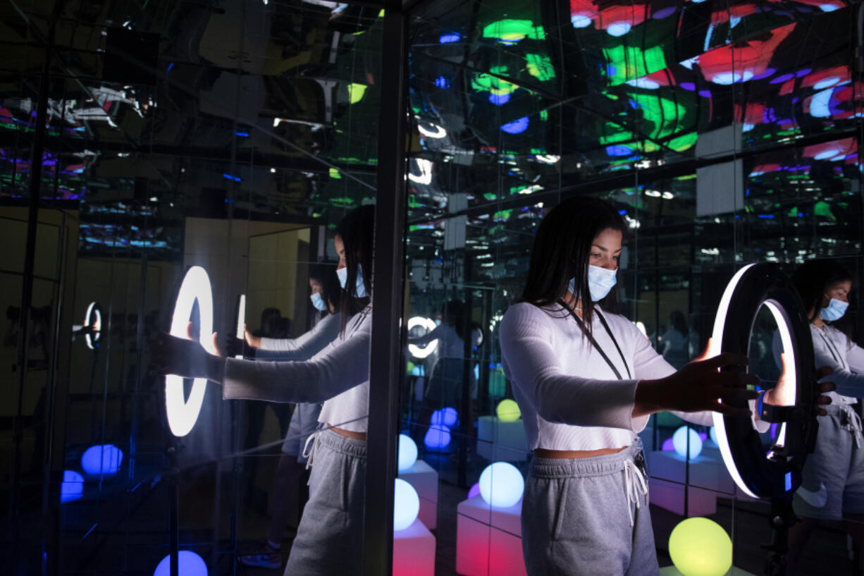 Mik Anthony, one of the owners of the new Stuntin' Selfie Studio, adjusts the lighting in a room that has glow-in-the-dark features and mirrors for selfie enthusiasts at Vancouver Mall on Monday morning. The photo studio features a collection of selfie backdrops for customers to use.