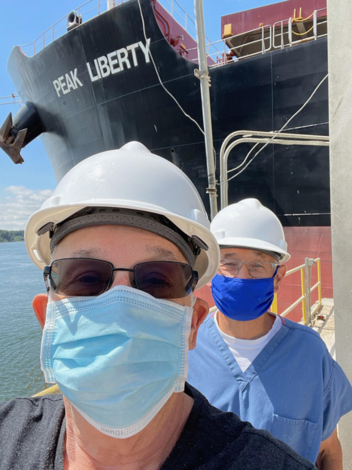 Brian Dolan, left, and Wayne VanHamme smile while on a ship to administer COVID-19 vaccines to international sailors docked at the Port of Longview.