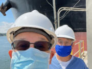 Brian Dolan, left, and Wayne VanHamme smile while on a ship to administer COVID-19 vaccines to international sailors docked at the Port of Longview.