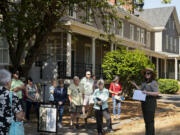 Guests listen to National Park Service curator Meagan Huff talk about the work immigrants performed at Vancouver Barracks in the 1880s. The former Infantry Barracks in the background now serves as headquarters of the Gifford Pinchot National Forest.