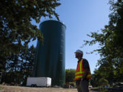 Tyler Clary, manager for water systems/water engineering for the city of Vancouver's water utility, pauses for a portrait with a 1 million gallon stand pipe at Water Station 1 in July 2021.