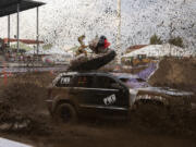 Vancouver's Chess Archibald powers his vehicle, including the inflatable duck and dinosaur strapped to its roof, through the mud during Friday's Tuff Trucks event at the Clark County Event Center at the Fairgrounds. Tuff Trucks was the first event in the Family Fun Series, which continues through Aug. 15.