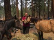 Veterinarian Tawnia Shaw, with The Happy Pet Vet team, examines horses that had been left during a Level 3 evacuation during the Bootleg Fire, Tuesday, July 13, 2021, near Sprague River, Ore.