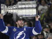 Tampa Bay Lightning defenseman Ryan McDonagh hoists the Stanley Cup after getting the win over the Montreal Canadiens in Game 5 of the NHL hockey Stanley Cup finals series, Wednesday, July 7, 2021, in Tampa, Fla. (AP Photo/Phelan M.