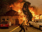 Fire consumes a home as the Sugar Fire, part of the Beckwourth Complex Fire, tears through Doyle, Calif., on Saturday, July 10, 2021. Pushed by heavy winds, the fire came out of the hills and destroyed multiple residences in central Doyle.