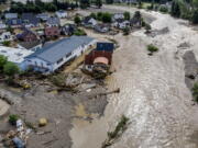 Damaged houses are seen at the Ahr river in Insul, western Germany, Thursday, July 15, 2021. Due to heavy rain falls the Ahr river dramatically went over the banks the evening before. People have died and dozens of people are missing in Germany after heavy flooding turned streams and streets into raging torrents, sweeping away cars and causing some buildings to collapse.