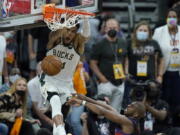 Milwaukee Bucks forward Giannis Antetokounmpo, top, dunks over Phoenix Suns guard Chris Paul during the second half of Game 5 of basketball's NBA Finals, Saturday, July 17, 2021, in Phoenix. (AP Photo/Ross D.