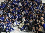 The Tampa Bay Lightning team poses with the Stanley Cup after Game 5 of the NHL hockey Stanley Cup finals against the Montreal Canadiens, Wednesday, July 7, 2021, in Tampa, Fla.