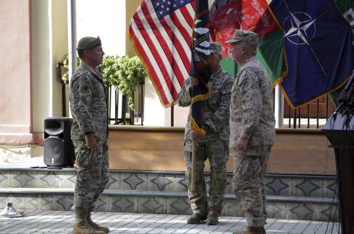 U.S. Army Gen. Scott Miller, the top U.S. commander in Afghanistan, left, hands over his command to Marine Gen. Frank McKenzie, the head of U.S. Central Command, right, at a ceremony at Resolute Support headquarters, in Kabul, Afghanistan, Monday, July 12, 2021. The United States is a step closer to ending a 20-year military presence that became known as its "forever war," as Taliban insurgents continue to gain territory across the country.