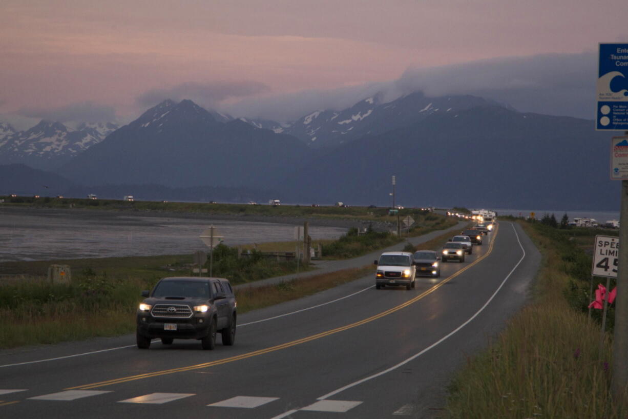 A line of cars evacuates the Homer Spit in Homer, Alaska on July 28, 2021, after a tsunami warning was issued following a magnitude 8.2 earthquake. The tsunami warning for much of Alaska's southern coast was canceled when the biggest wave, of just over a half foot, was recorded in Old Harbor. Alaska.