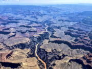 This photo provided by John Dillon shows the effects of flooding in the Colorado River through the Grand Canyon on Thursday, July 15, 2021. The river that's normally a greenish color turned a muddy brown from flash floods that have inundated Arizona. Authorities are searching for two people who were on a river rafting trip through the Grand Canyon and went missing after a flash flood, a park spokeswoman said Thursday.