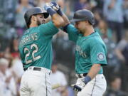 Seattle Mariners' Cal Raleigh, right, is greed by Luis Torrens (22) after Raleigh hit a two-run home run against the Oakland Athletics during the second inning of a baseball game, Friday, July 23, 2021, in Seattle. Torrens hit a solo home run in his ensuing at-bat. (AP Photo/Ted S.