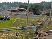 A damaged car and other debris are strewn across a soccer stadium playing field after flooding in Vaux-sous-Chevremont, Belgium, Saturday, July 24, 2021. Residents were still cleaning up after heavy rainfall hit the country causing flooding in several regions.